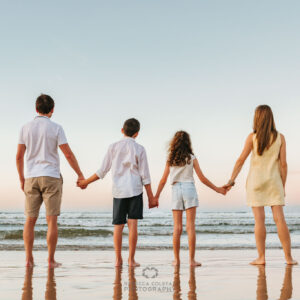 Noosa family photographer capturing a family holding hands at dusk